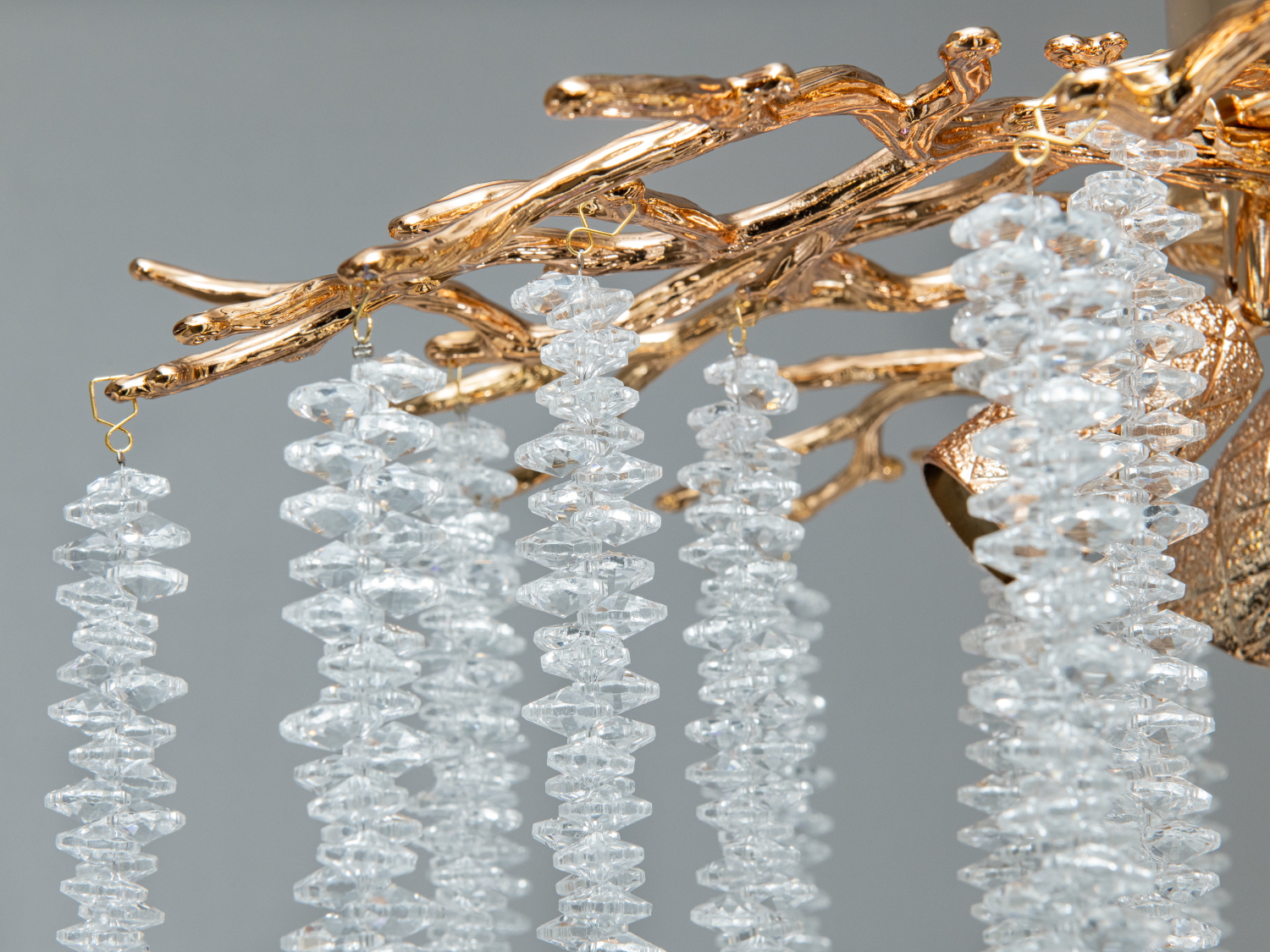 Деталь кріплення кришталевих підвісок на золотистій основі люстри. Підходить для розкішних інтер′єрів.