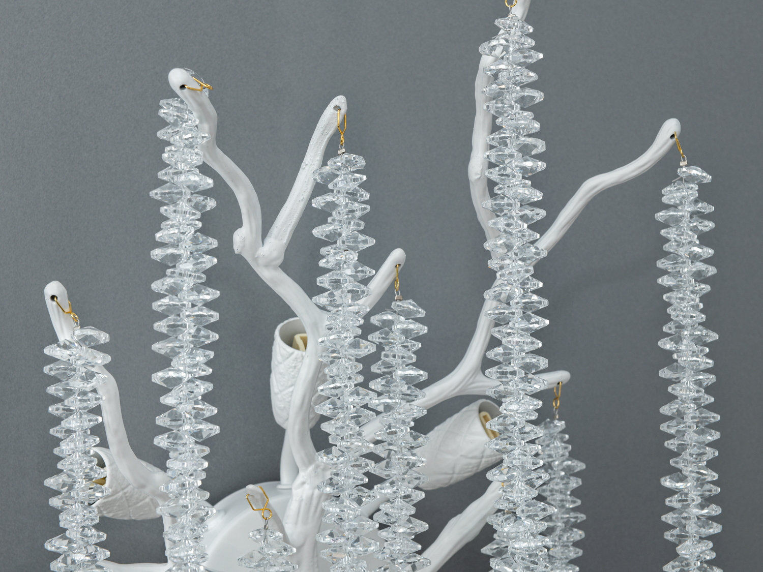 Детальний вигляд настінного світильника з білими гілками та підвісками з прозорого кришталю. Ідеально підходить для вітальні або спальні.