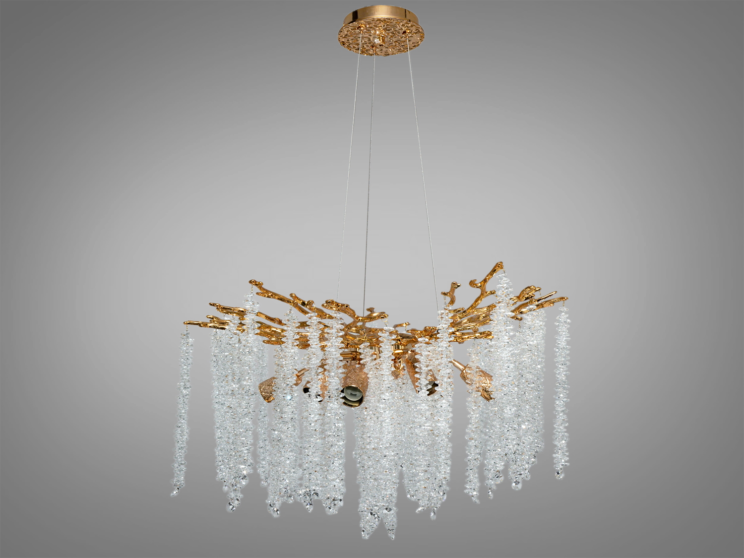 Люстра з підвісними кришталевими елементами, закріплена на стелі, має золотисту основу у формі гілок Гліцинії, підходить для вітальні.
