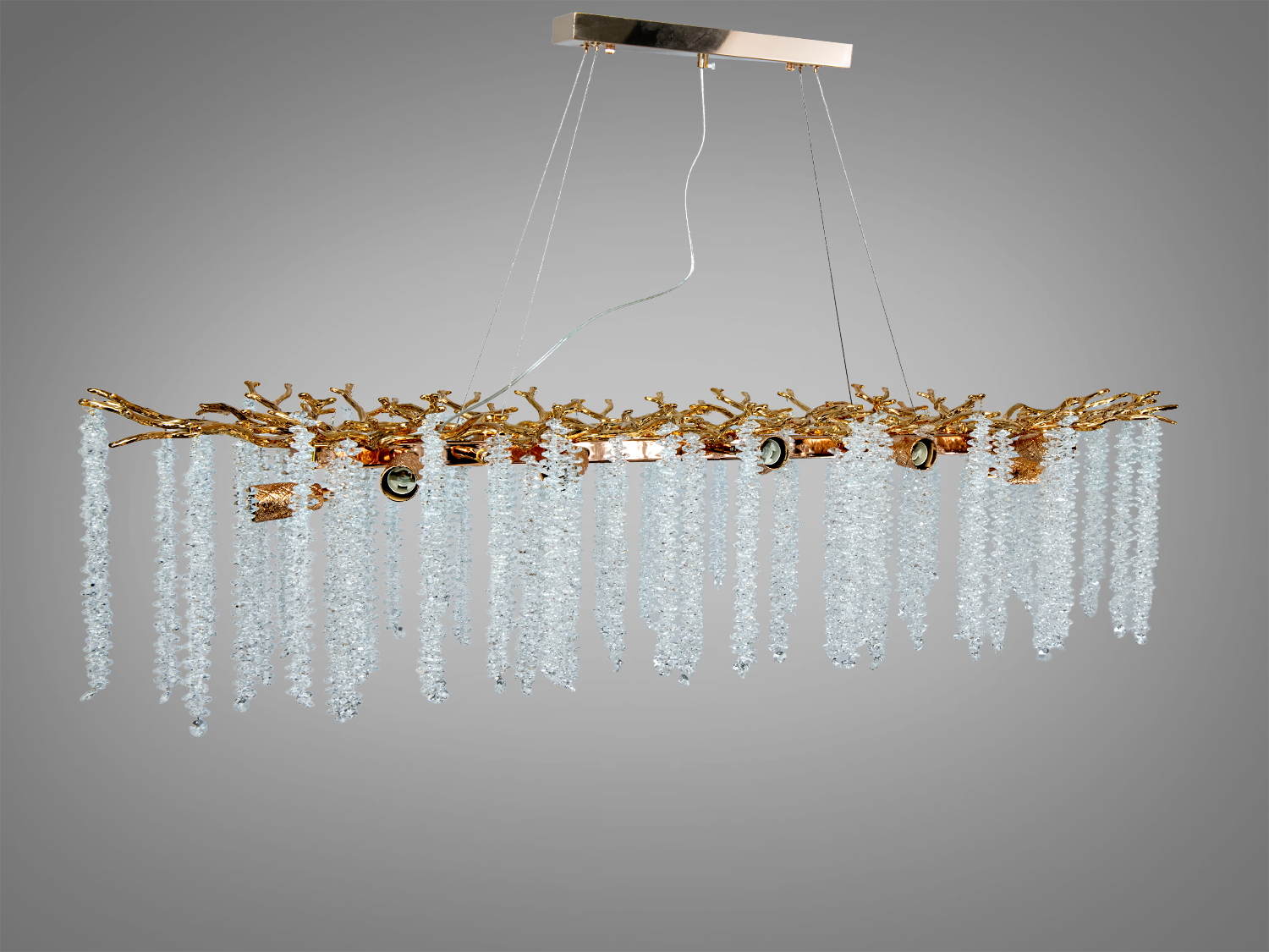 Довга люстра з кришталевими підвісками та золотими елементами, підвішена на тонких дротах. Підходить для просторих залів.