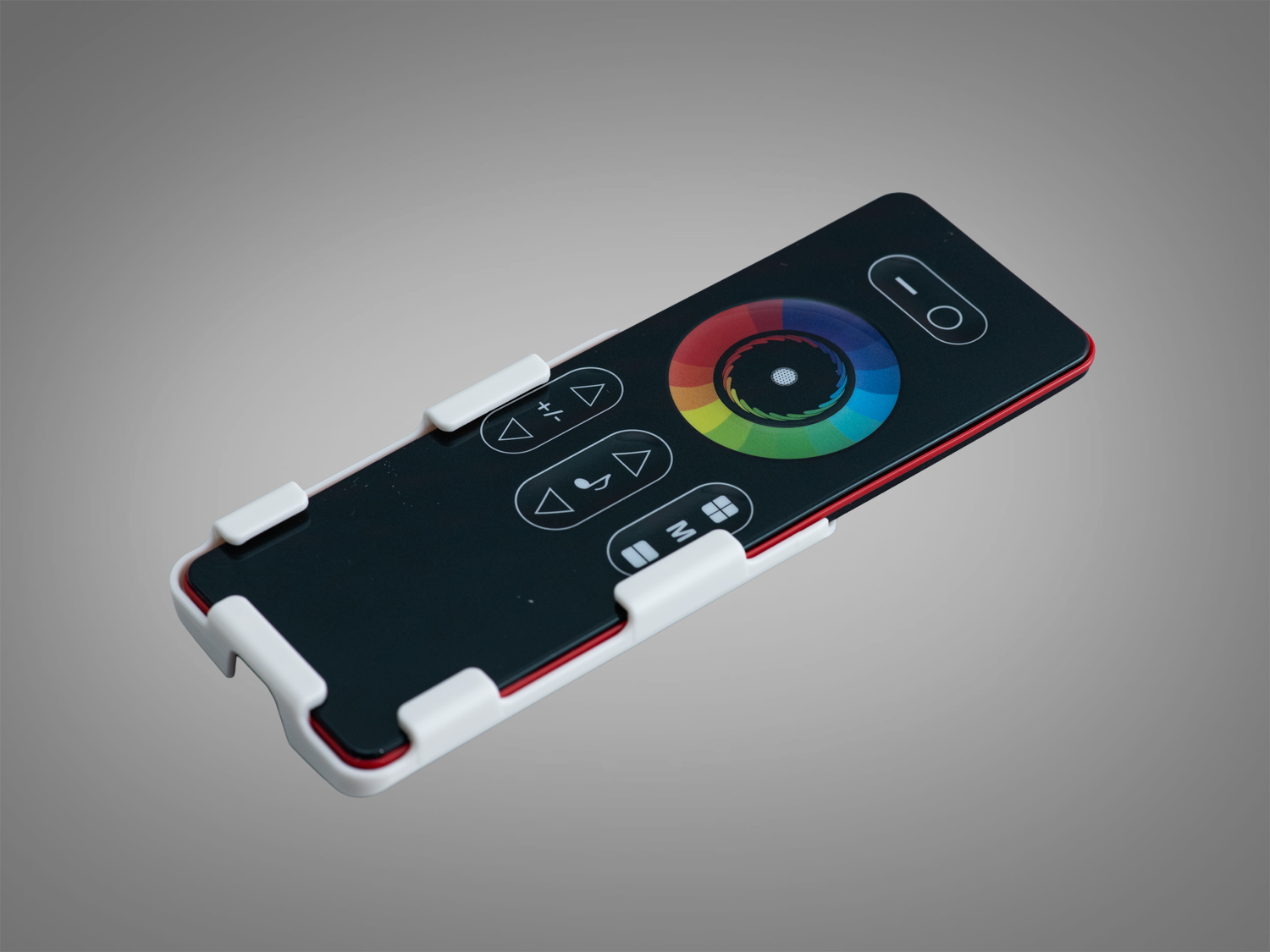 Пульт у білому тримачі, чорний корпус, сенсорне кільце для вибору кольору, призначений для управління освітленням.