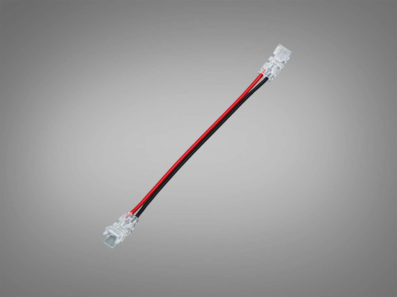 Прозорий конектор з червоним і чорним проводами, призначений для підключення світлодіодних стрічок.