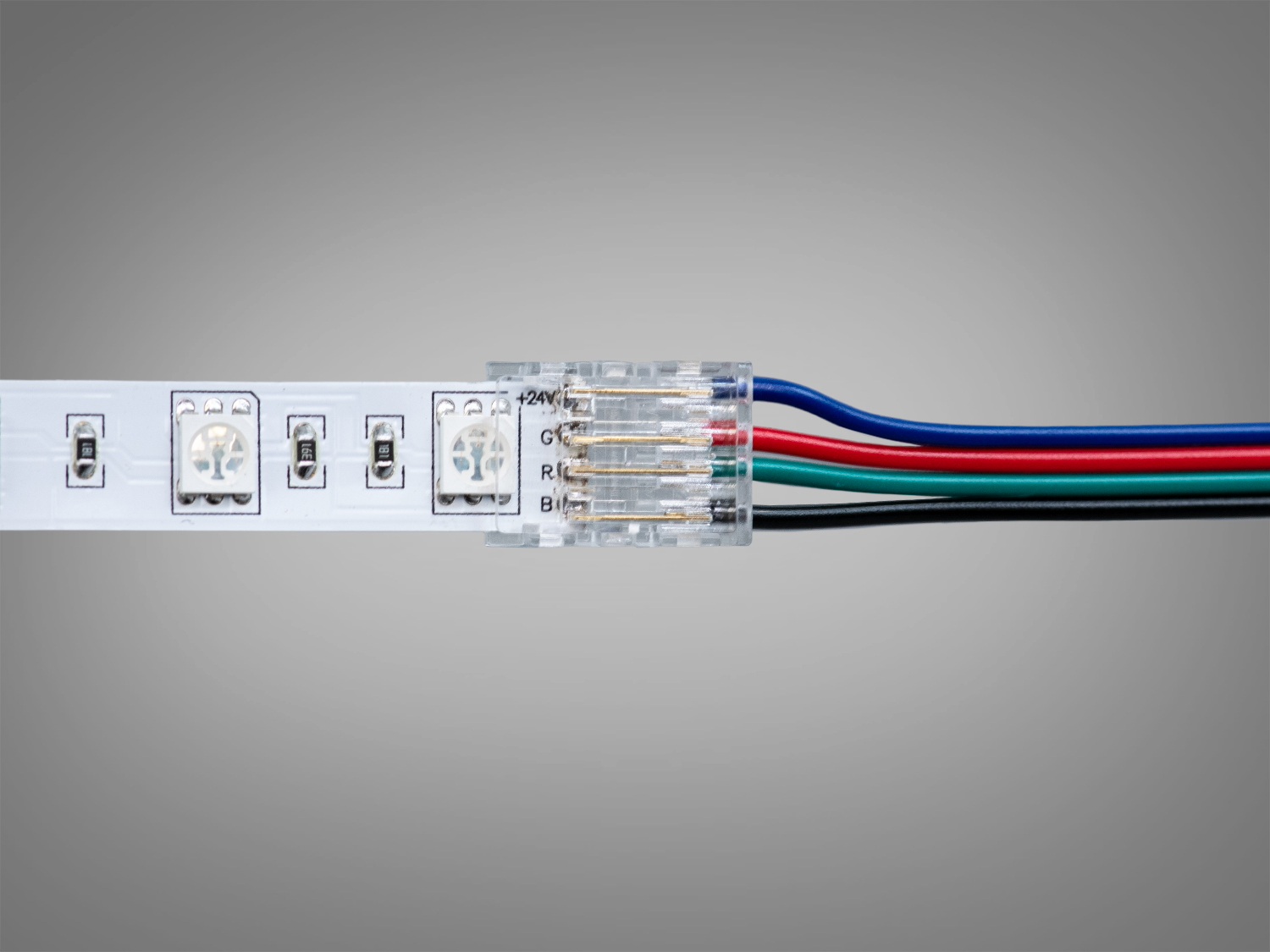Світлодіодна стрічка з підключеним роз′ємом. Чотири кольорові проводи: чорний, зелений, червоний, синій. Прозорий корпус роз′єму.