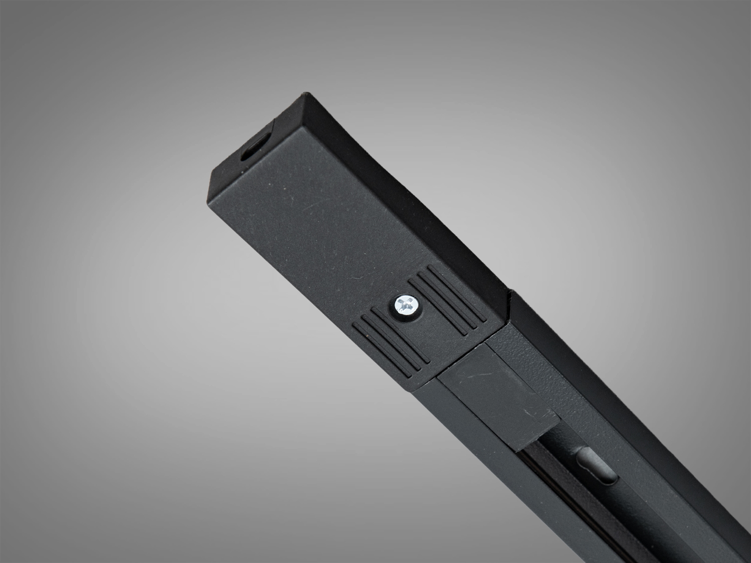 Кінцева частина чорного трекового профілю з гвинтовим кріпленням, призначена для надійного з′єднання в системах освітлення.