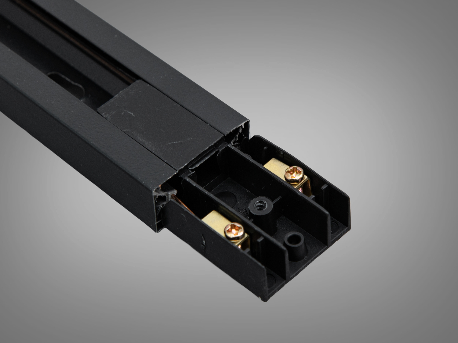 Чорний трековий профіль з відкритими контактами для підключення, забезпечує електричний зв′язок у системах трекового освітлення.