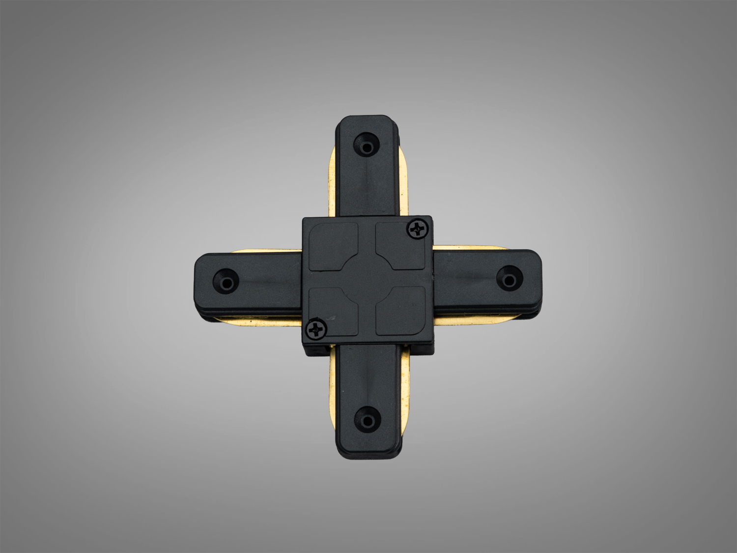 Чорний з′єднувач у формі хреста з гвинтами для монтажу. Використовується для підключення трекових світильників у комерційних приміщеннях.