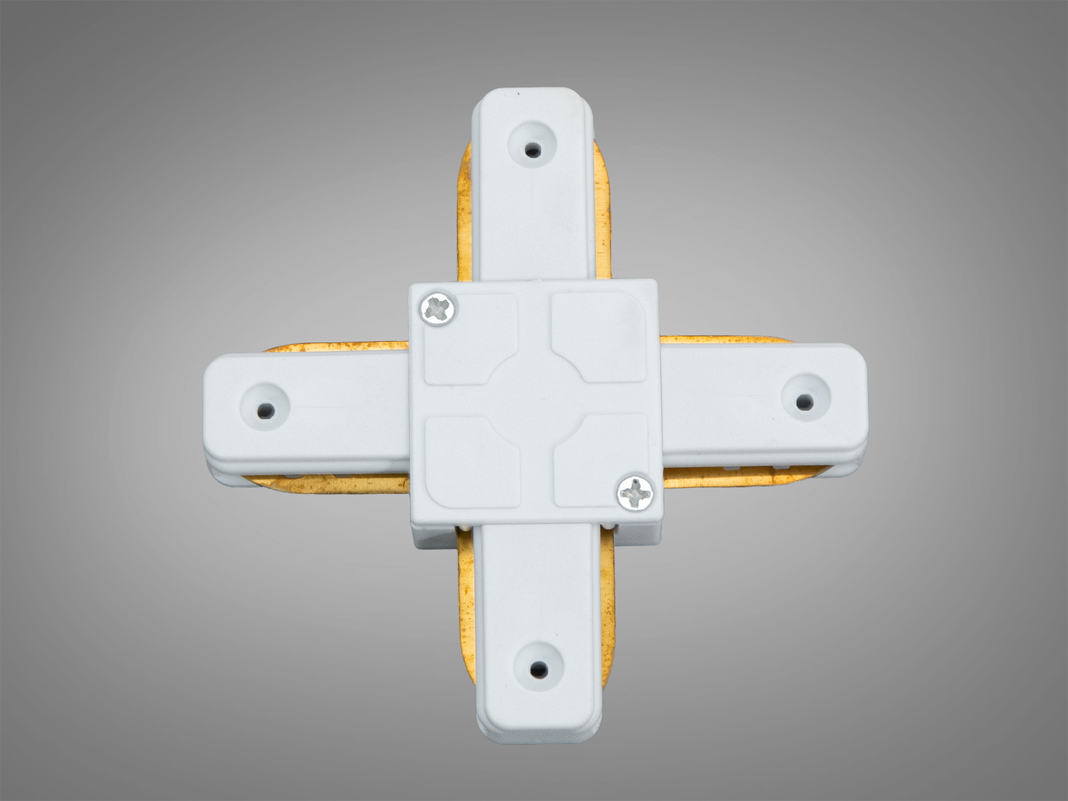 Нижня частина хрестоподібного з′єднувача для трекового освітлення з видимими кріпильними гвинтами, що забезпечують надійність монтажу в системах освітлення.