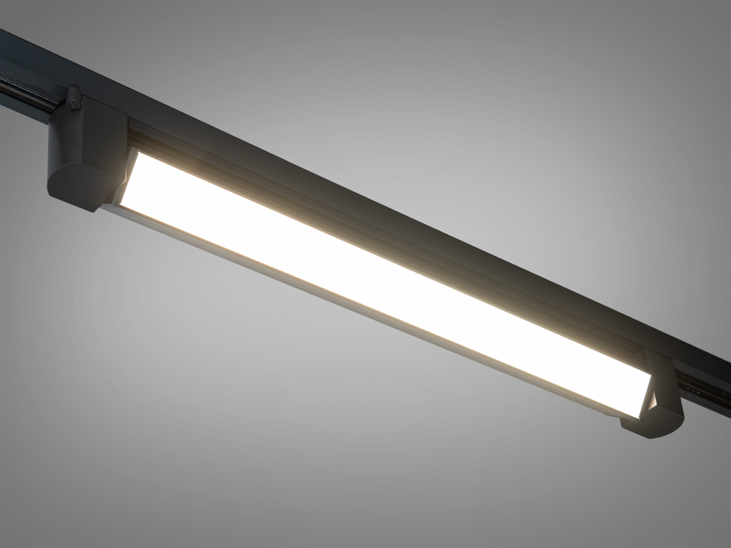 Світлодіодний світильник з теплим білим світлом, встановлений на трековій системі. Підходить для житлових інтер′єрів.