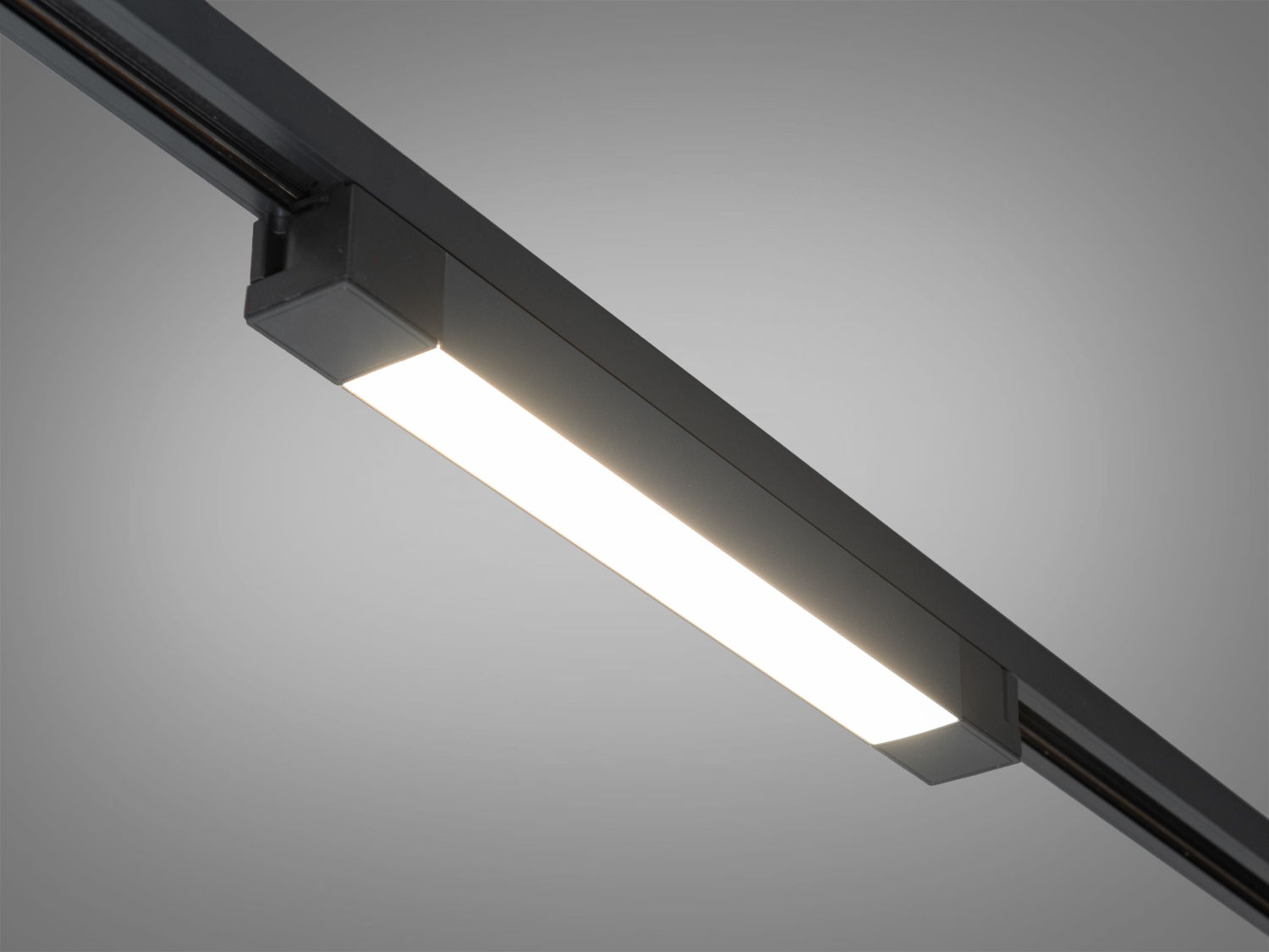 Світлодіодний світильник в чорному корпусі, встановлений на трековій системі, підходить для сучасних інтер′єрів.
