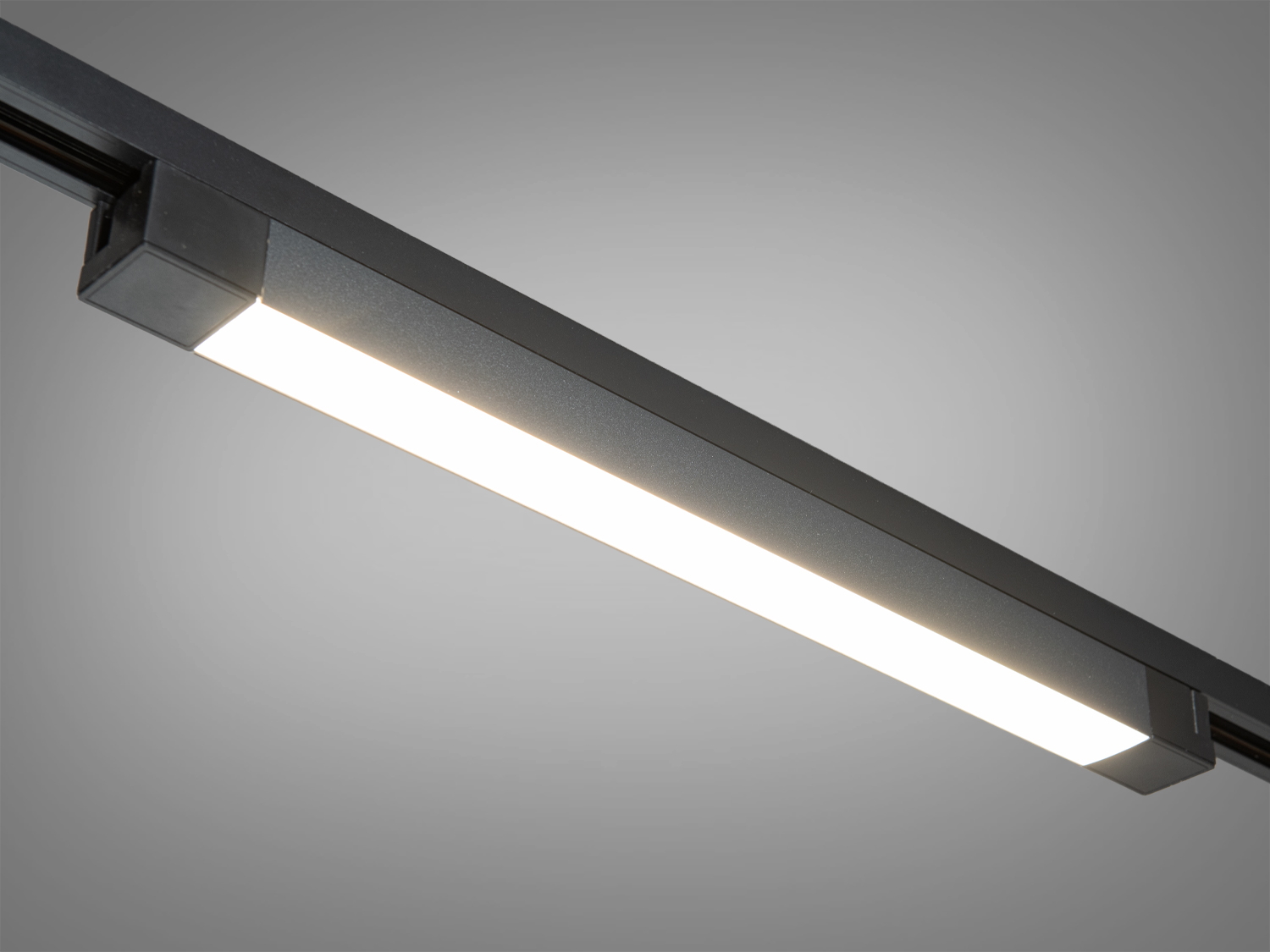 Світлодіодний світильник з чорним корпусом, оснащений трековою системою монтажу, забезпечує яскраве освітлення для комерційних приміщень.