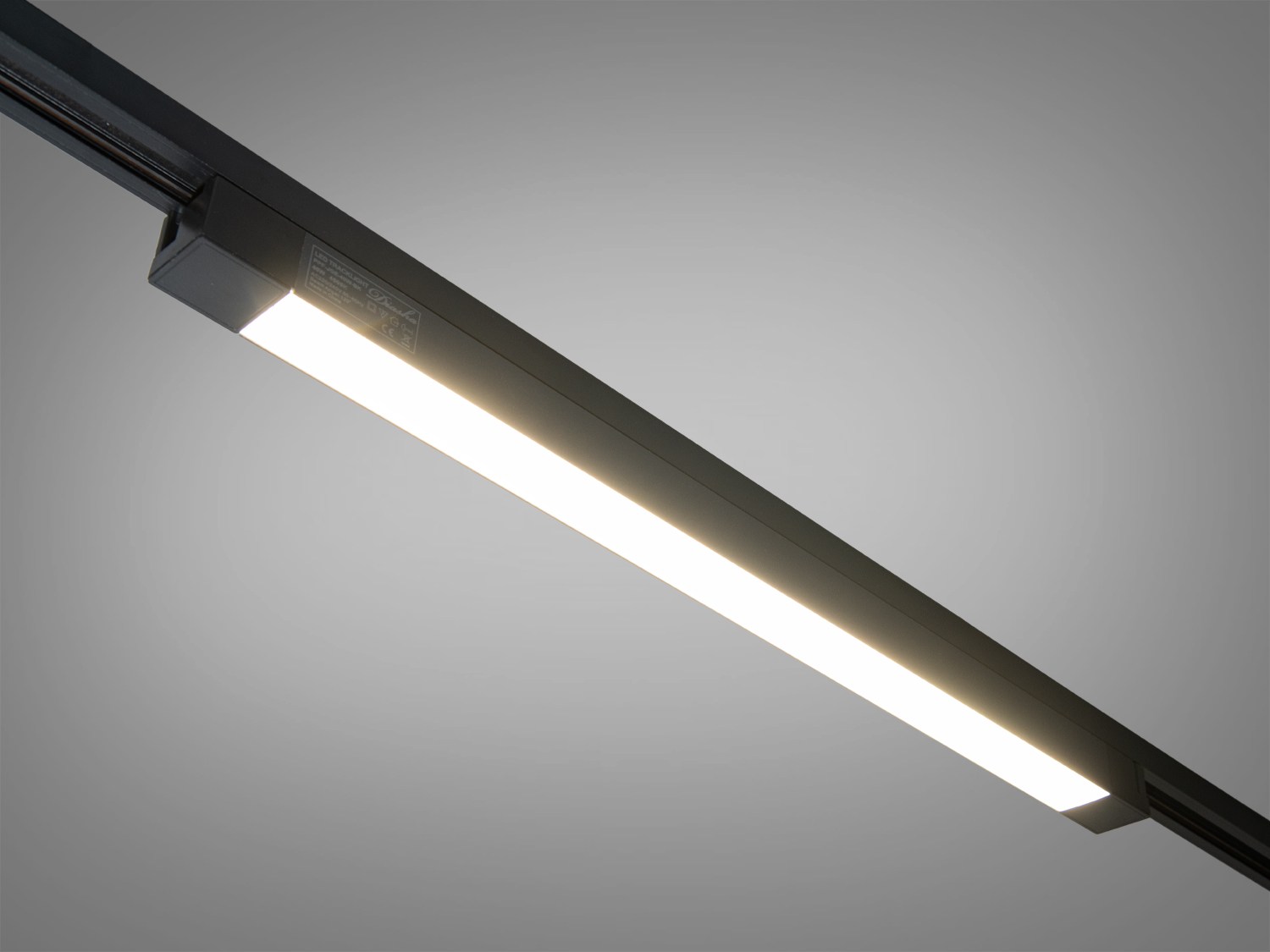 Лінійний світильник з теплим білим світлом, чорний корпус, підходить для освітлення робочих зон.