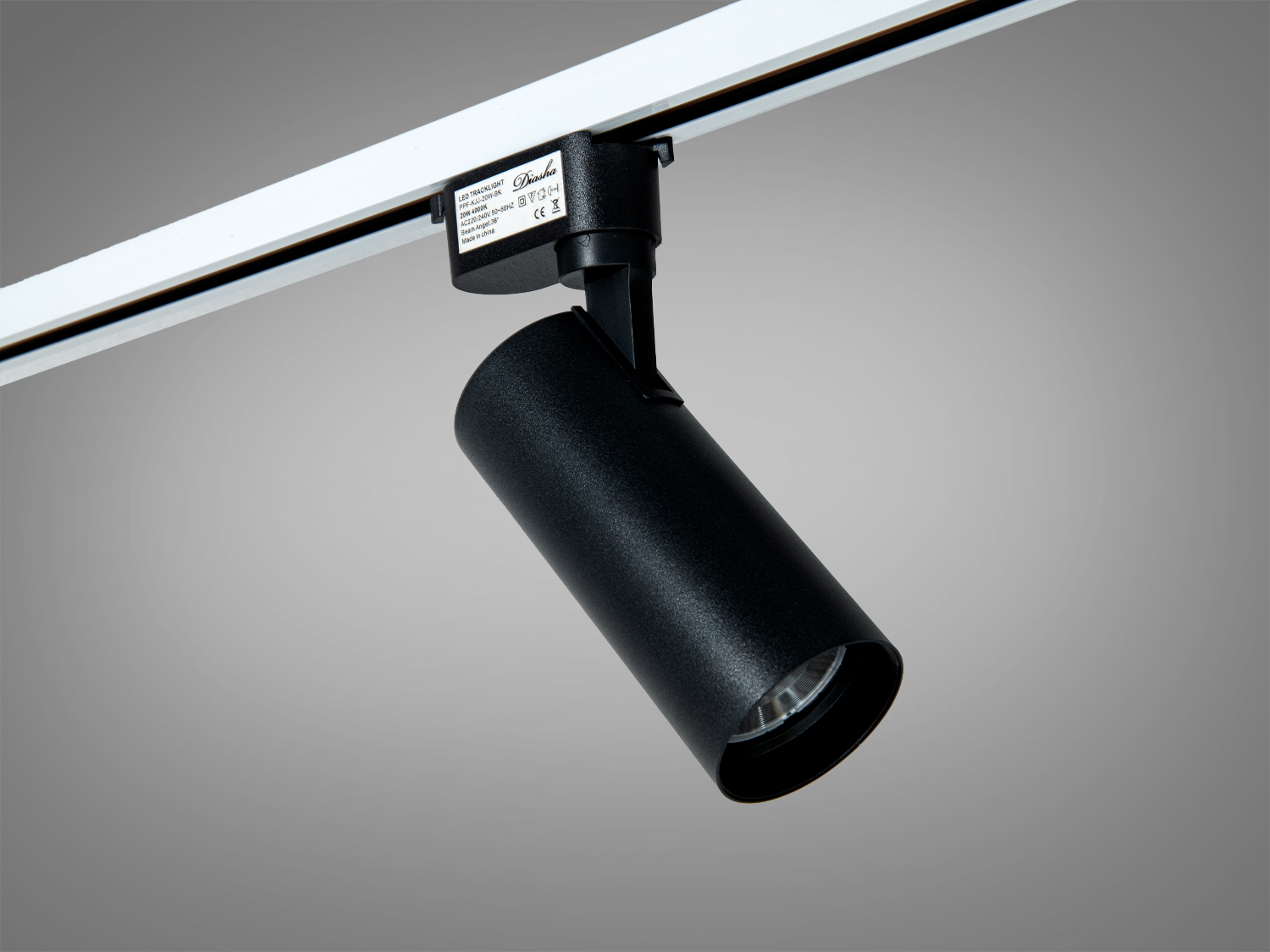 Компактний чорний трековий світильник циліндричної форми, ідеальний для освітлення виставкових просторів.