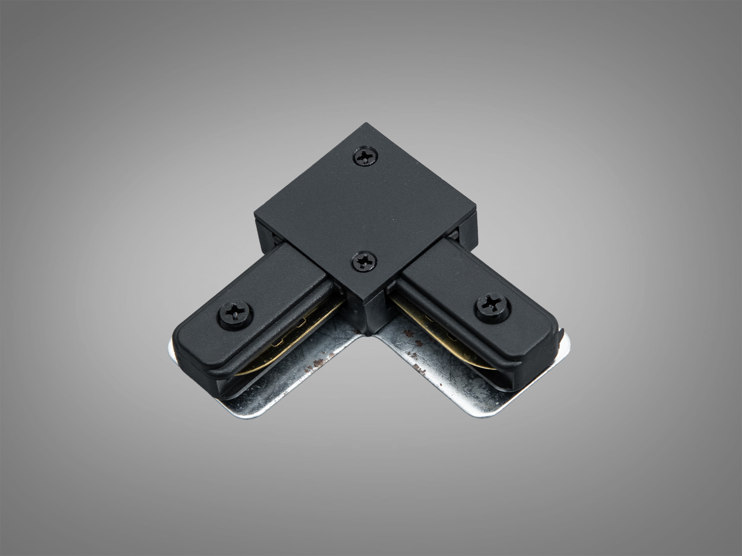 Чорний кутовий L‑з’єднувач для трекової системи 220В серії 1209. Накладний конектор 90° з пластиковим корпусом і металевими елементами для надійного стику.