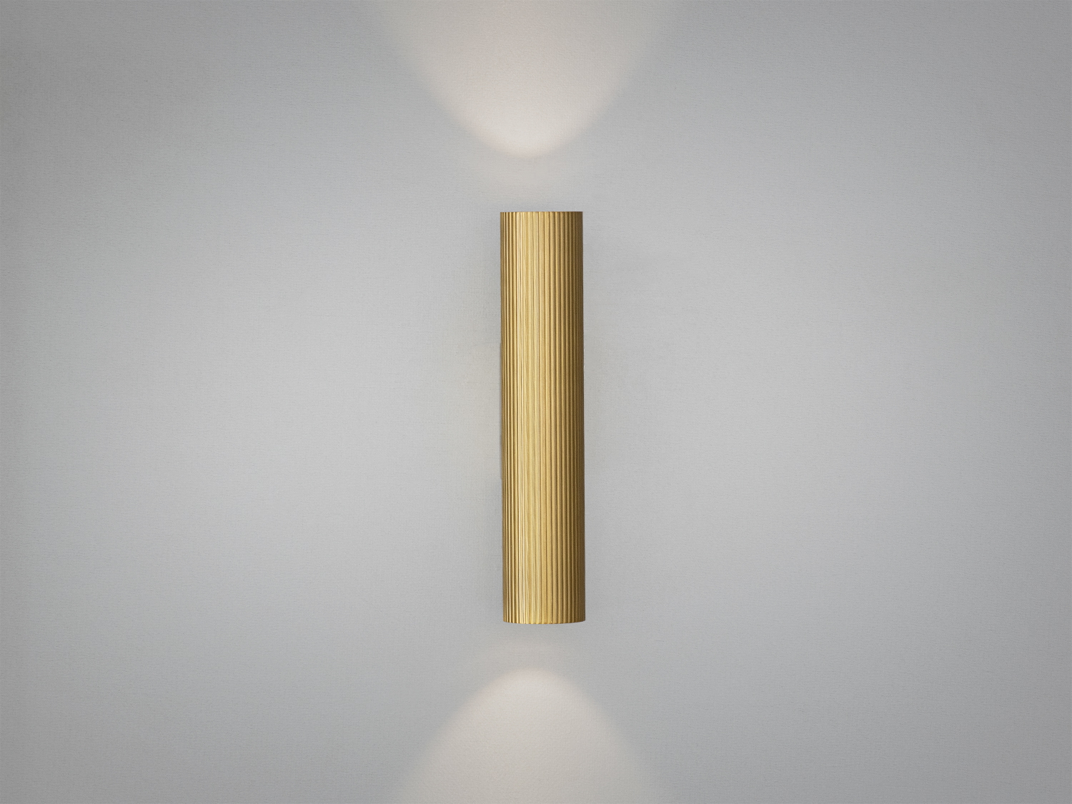 Металевий настінний світильник з рифленою поверхнею, який випромінює світло вгору та вниз. Ідеальний для акцентного освітлення.