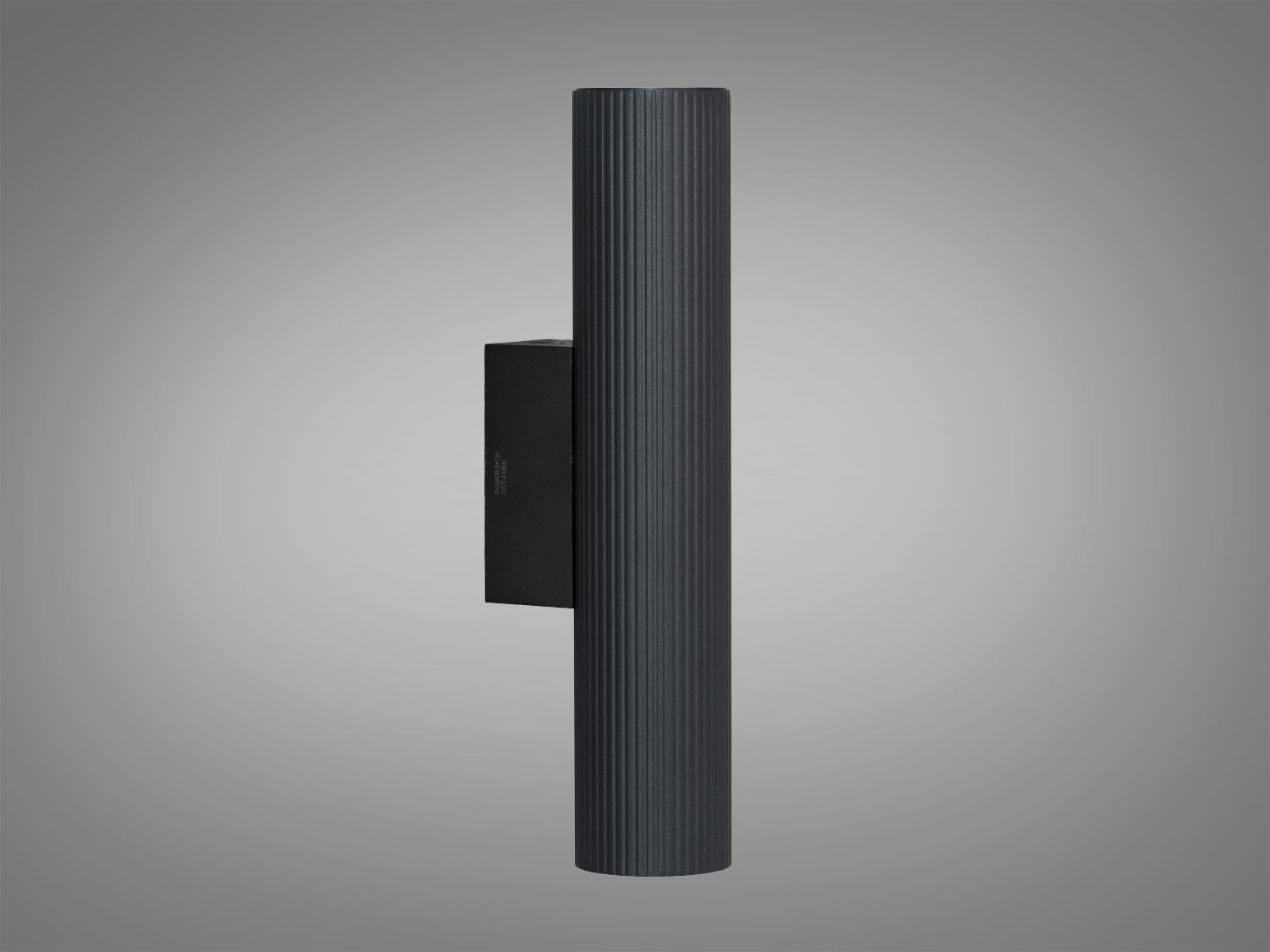 Циліндричний світильник із рифленою поверхнею, чорний метал, призначений для настінного монтажу, забезпечує спрямоване освітлення.