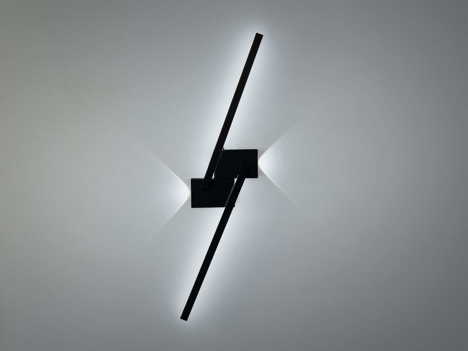 Сучасний настінний світильник з чорними лініями, що перетинаються, створює затишне освітлення. Підходить для вітальні або спальні.