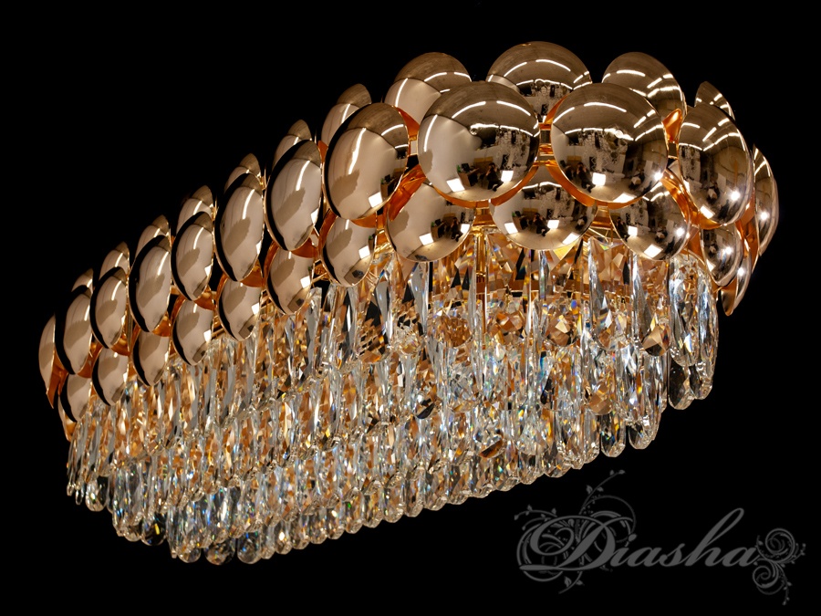 Люстра з блискучими золотими дисками та прозорими підвісками, створює ефектний світловий акцент у просторі.