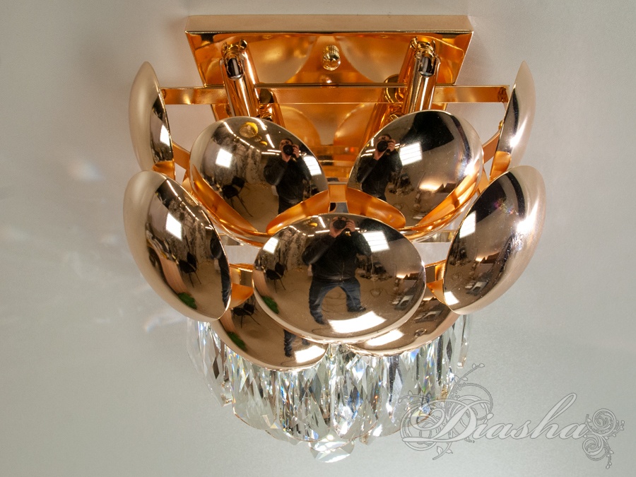 Кришталі світильника мають однаковий розмір, ніби танцюють у ритмі відблисків та променів, що виходять із їхнього центру.