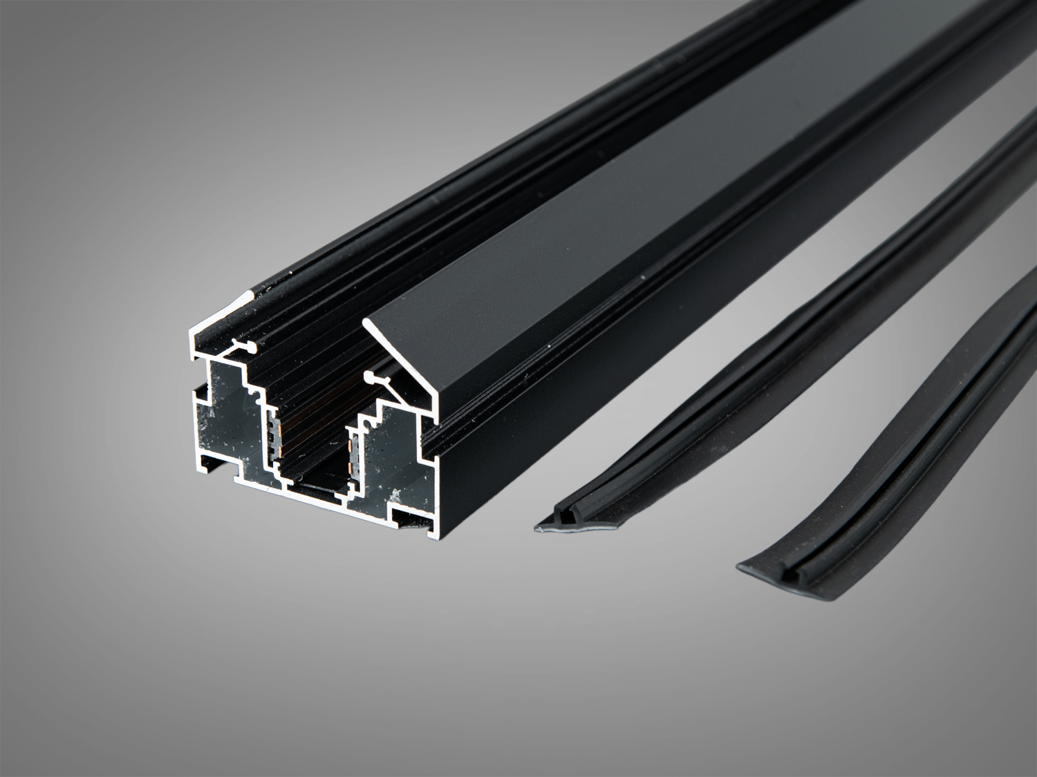 Чорний алюмінієвий профіль з додатковими гумовими вставками для забезпечення герметичності, використовується у вбудованих освітлювальних системах.