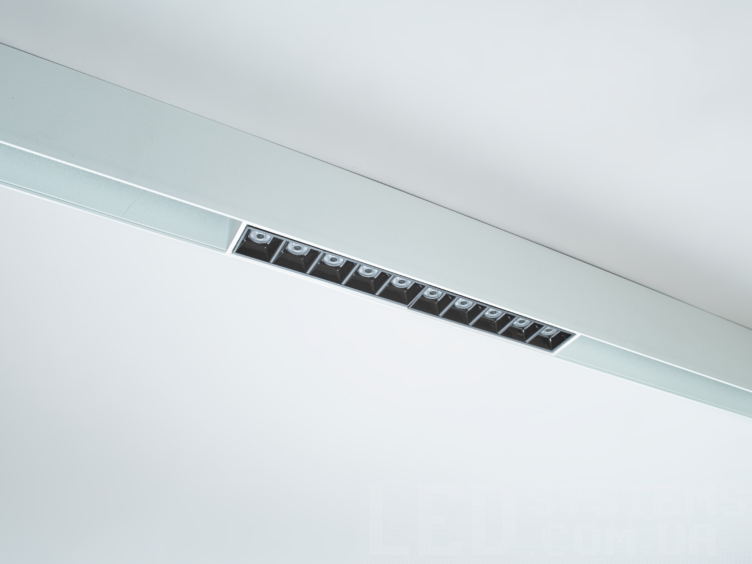 Передня панель трекового світильника лед оснащена рядом інтегрованих лінз, які рівномірно розподіляють світло, формуючи чіткий і сфокусований промінь.