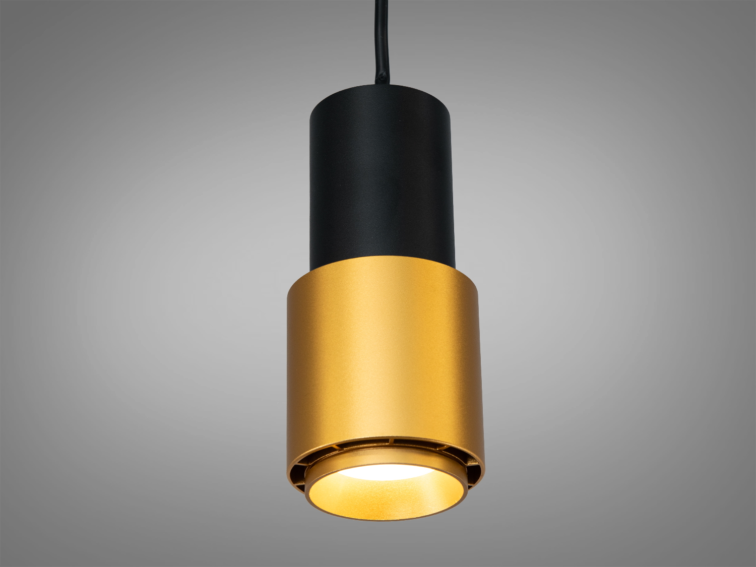 Підвісний світильник циліндричної форми з чорним корпусом та золотистим відтінком, підходить для сучасних інтер′єрів.