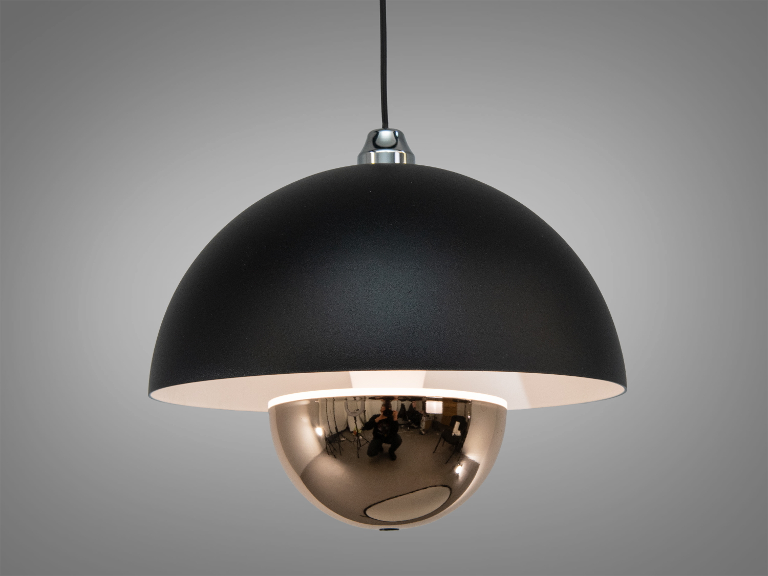 Підвісний світильник з гладким білим абажуром і дзеркальною сферою, що забезпечує м′яке розсіювання світла, підходить для вітальні.