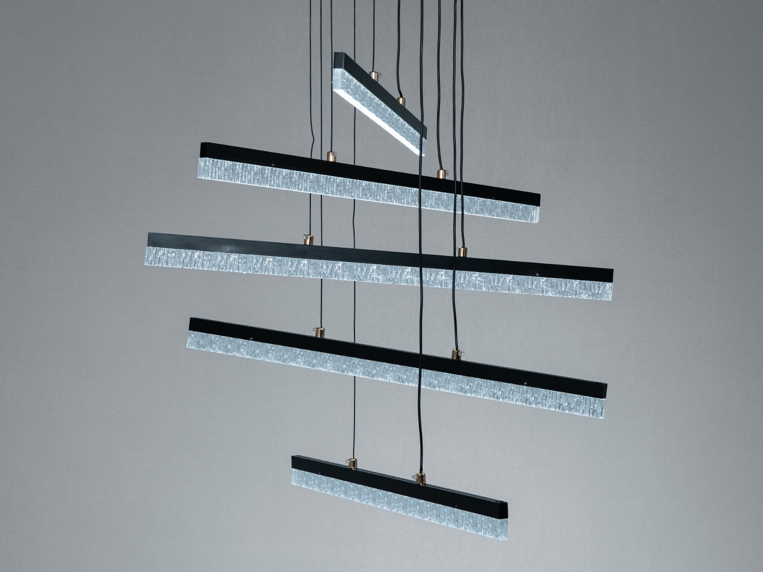 Лампа з п′яти світлодіодних панелей, розташованих під різними кутами, підвішена на тонких дротах, ідеальна для сучасного освітлення.