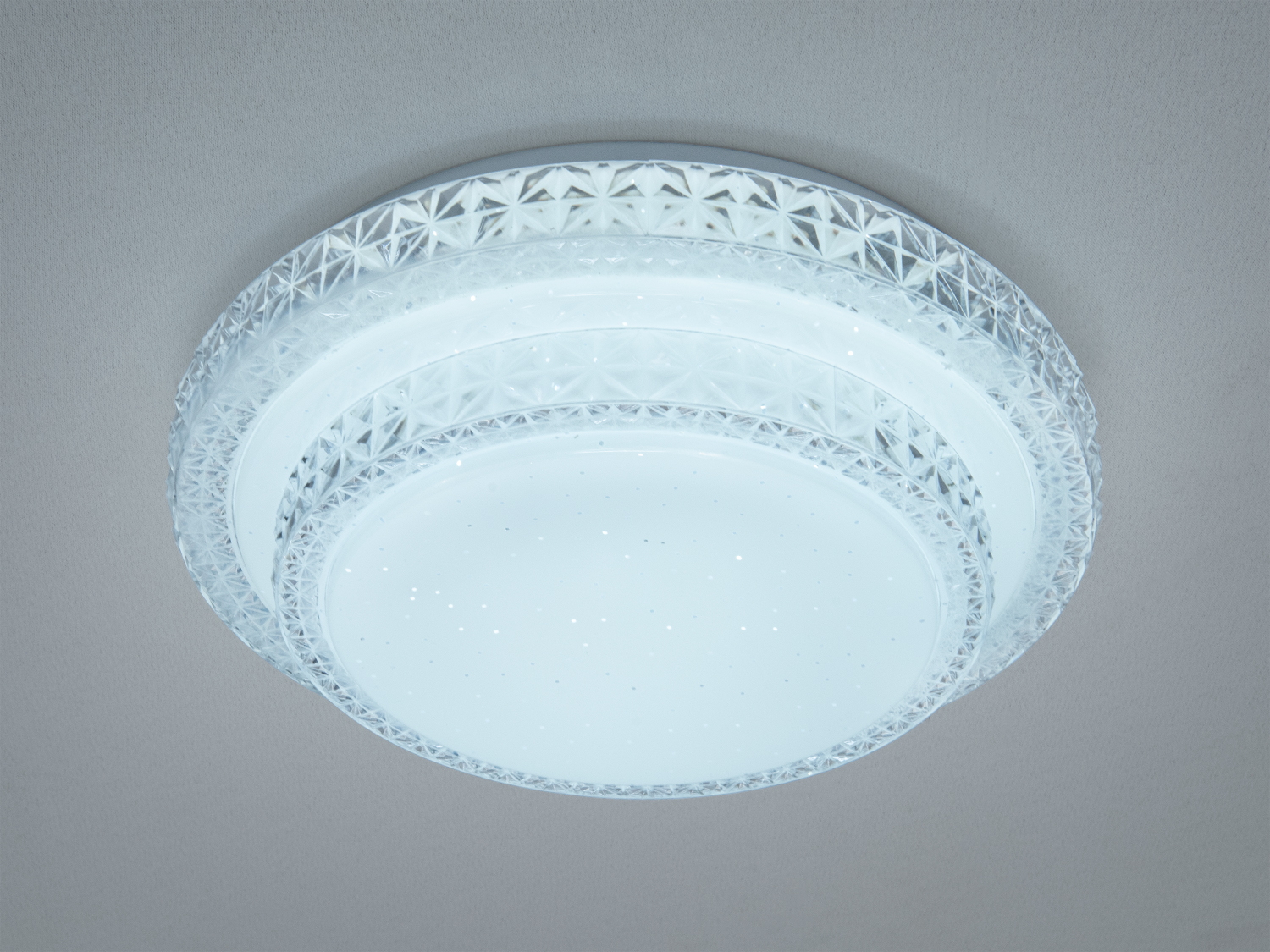 Стельовий світильник з прозорим візерунковим акриловим обрамленням, що випромінює холодне біле світло. Підходить для офісних приміщень.