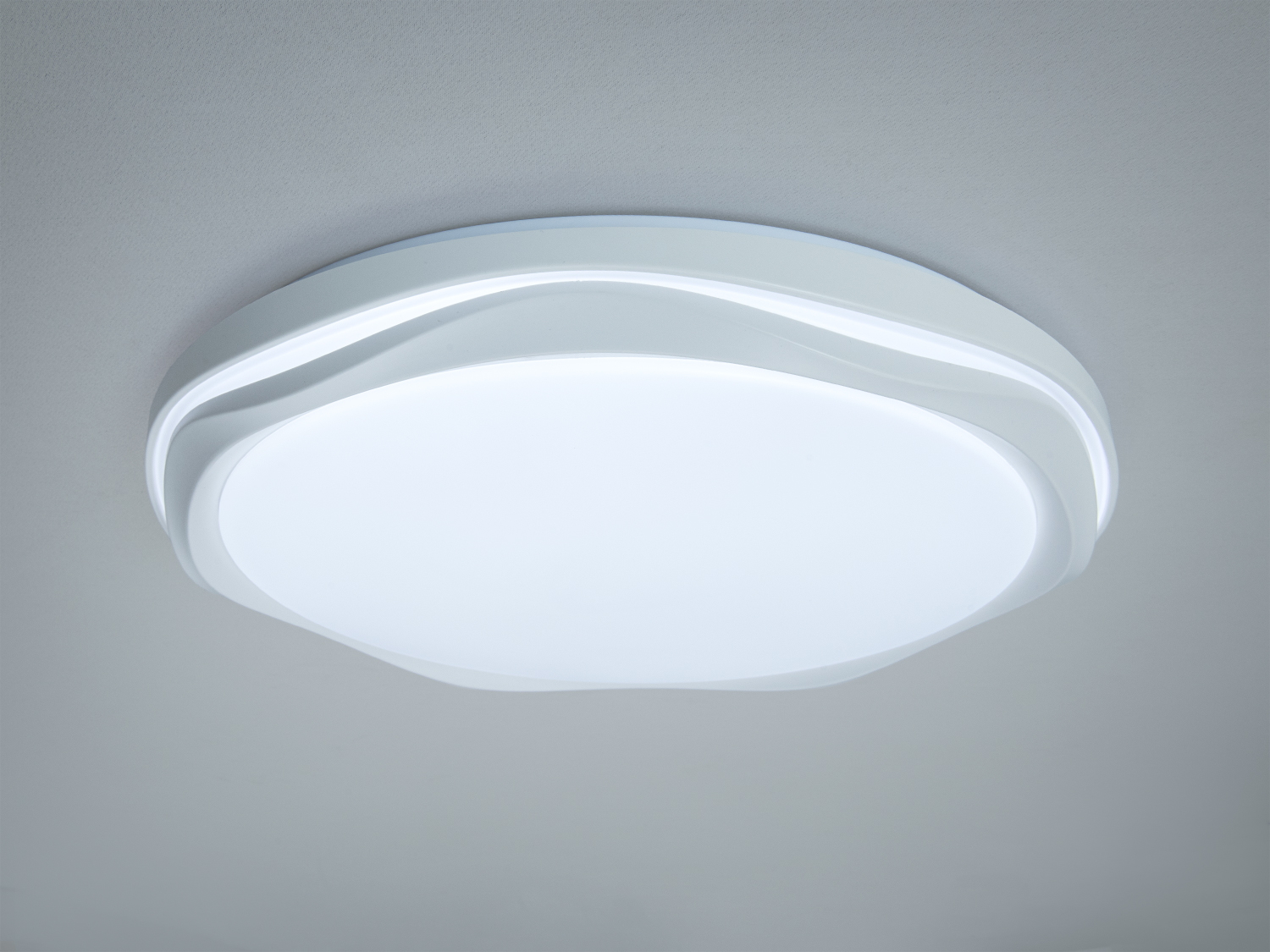 Круглий стельовий світильник з білим корпусом та хвилястим дизайном, підходить для сучасних інтер′єрів.