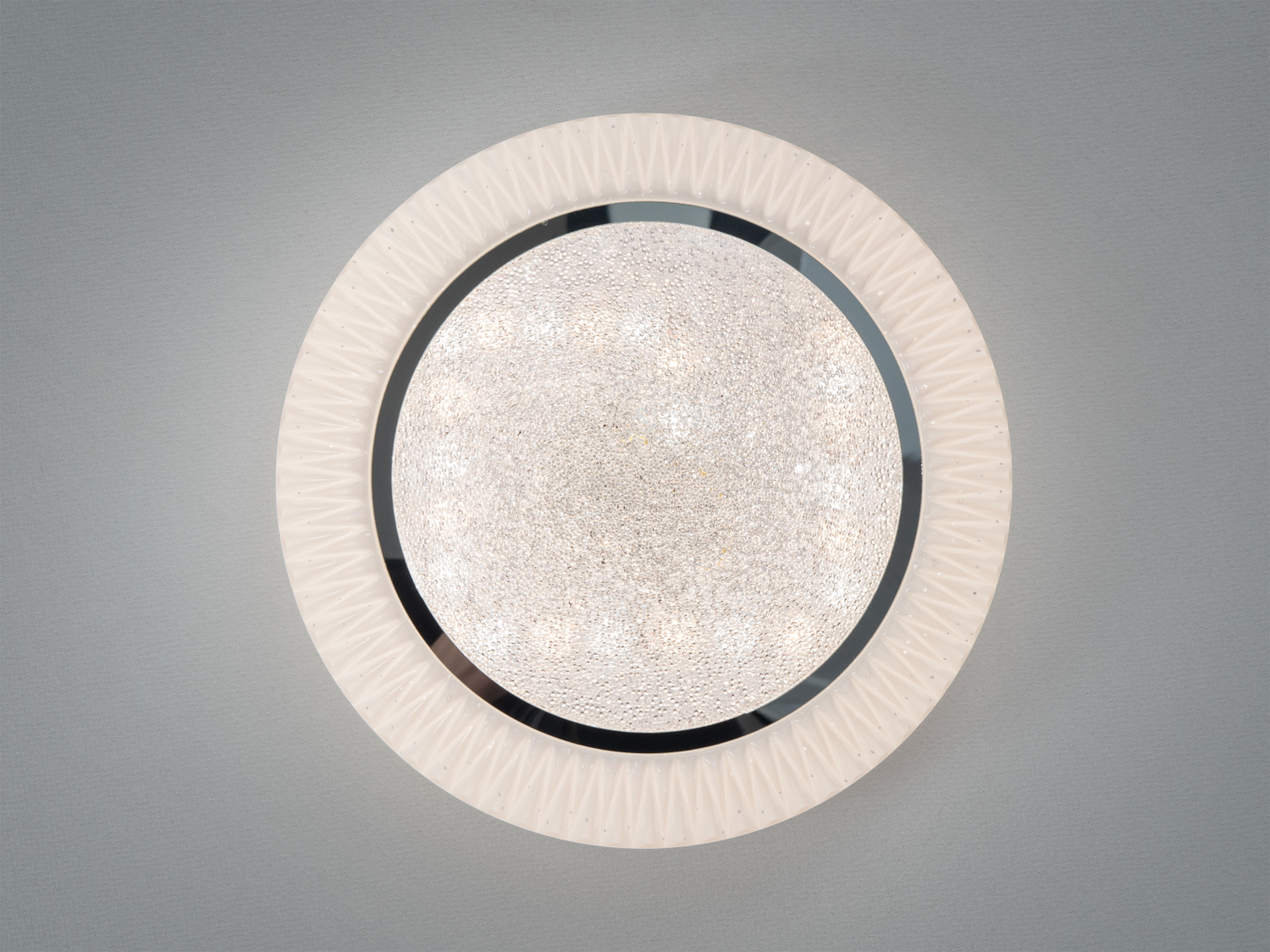 Стельова лампа з рельєфним пластиковим обрамленням і скляним центром, підходить для монтажу в сучасному інтер′єрі.