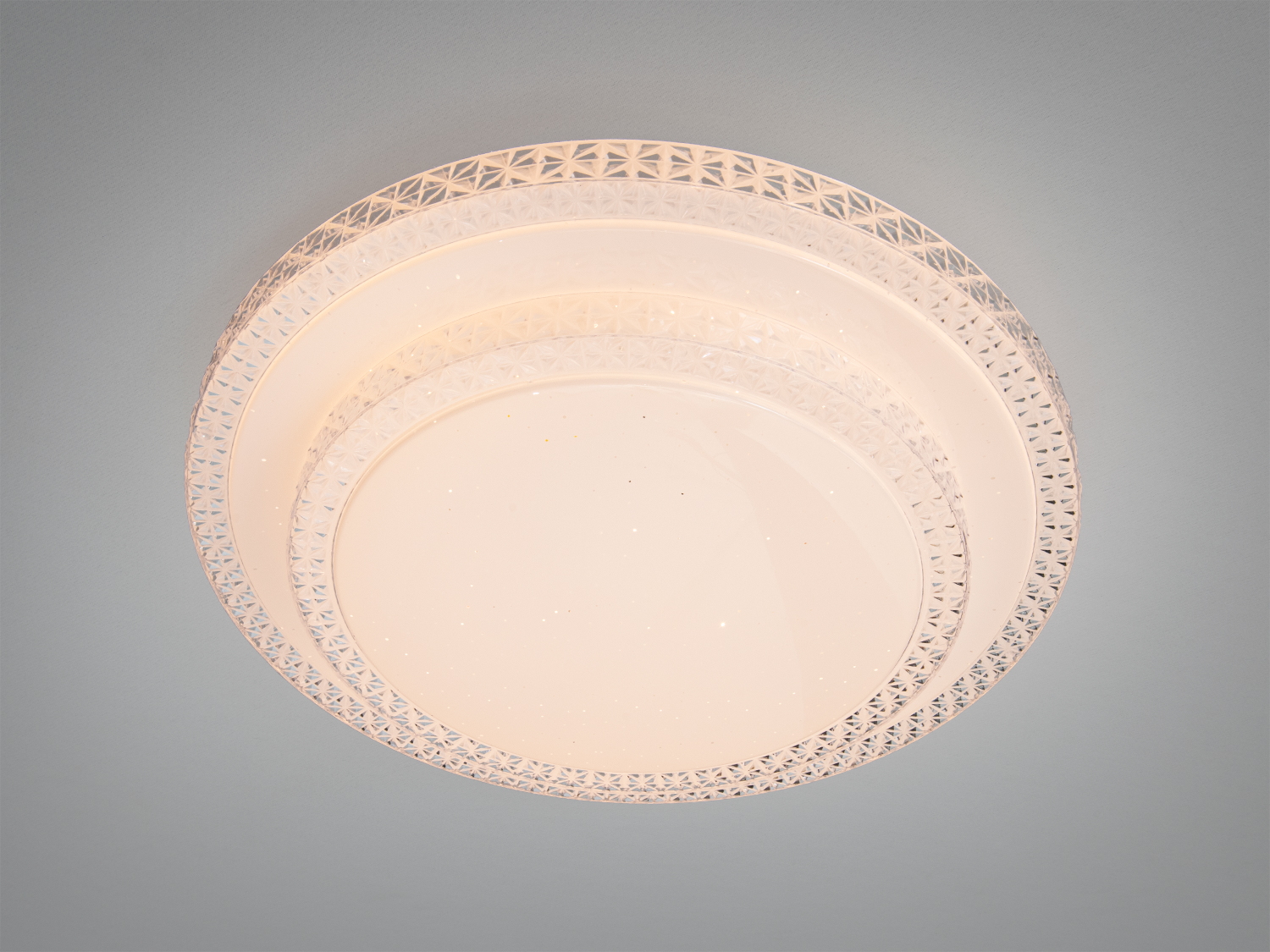 Кругла стельова лампа з візерунковим краєм, що випромінює тепле світло. Ідеально підходить для вітальні, створюючи затишну атмосферу.