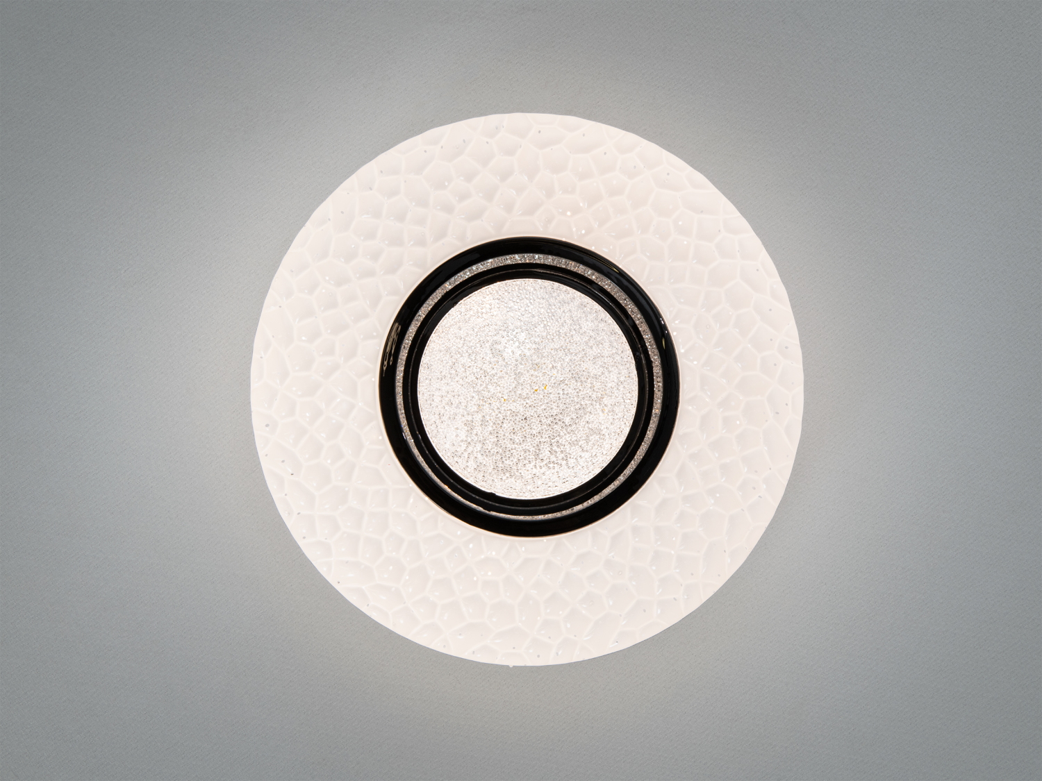 Білий стельовий світильник з текстурованою поверхнею, чорна окантовка, розсіює світло рівномірно. Ідеально підходить для сучасних інтер′єрів.