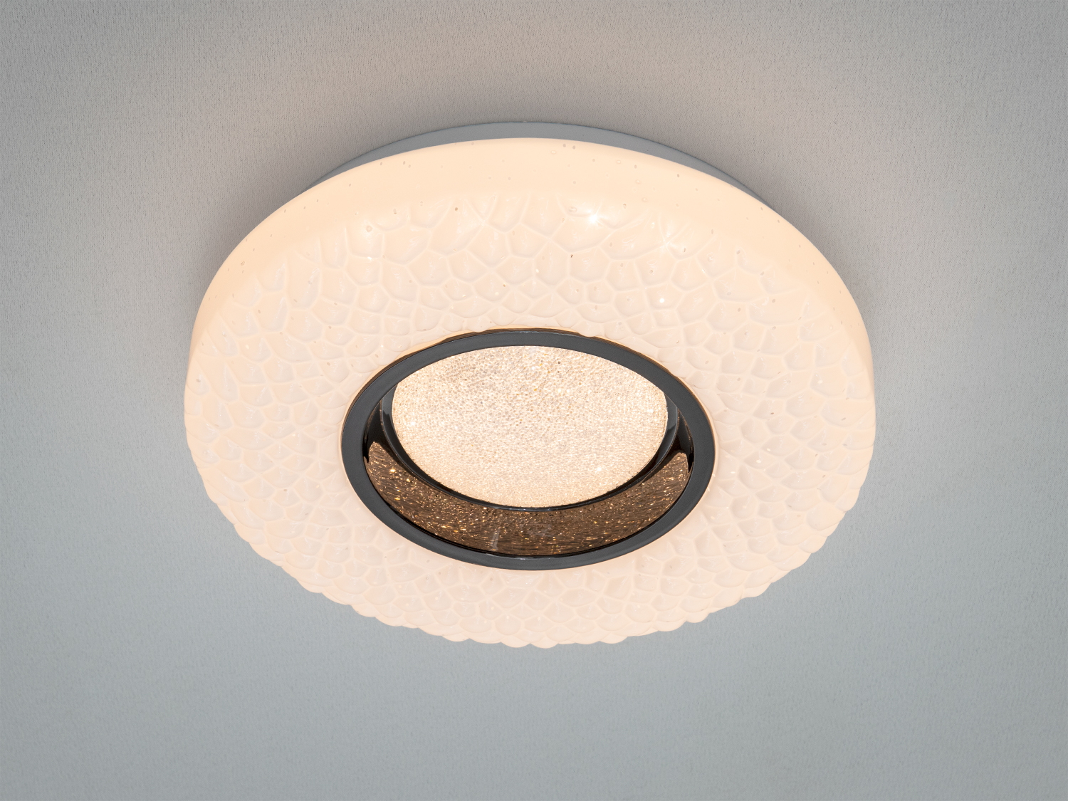 Стельовий світильник з об′ємною текстурою, білий з чорними акцентами, забезпечує м′яке освітлення. Призначений для житлових приміщень.