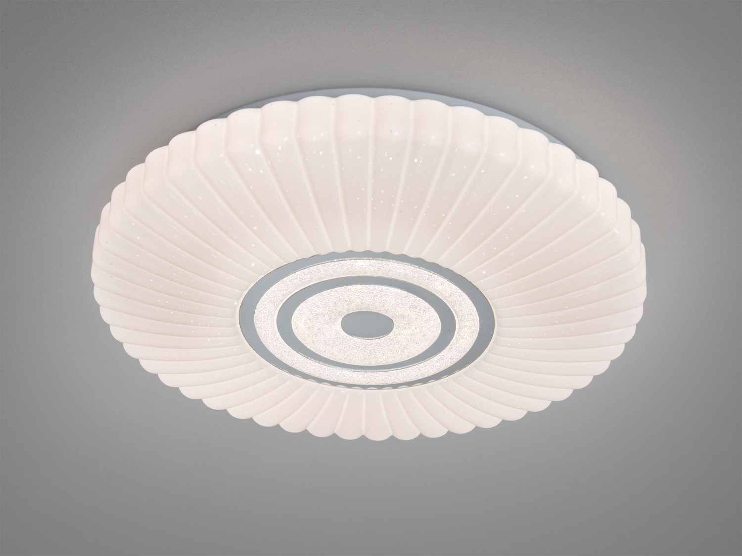 Стельова лампа з білим рельєфним абажуром, що нагадує пелюстки, з бічним видом. Металевий центр додає стильності, ідеальна для кухні.