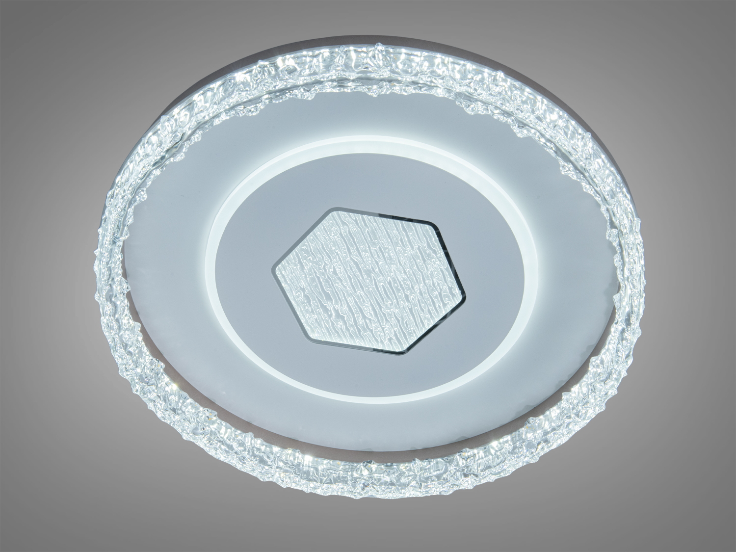 Стельова лампа з текстурованим обідком, що випромінює холодне світло. Центральний шестикутник додає геометричної естетики.
